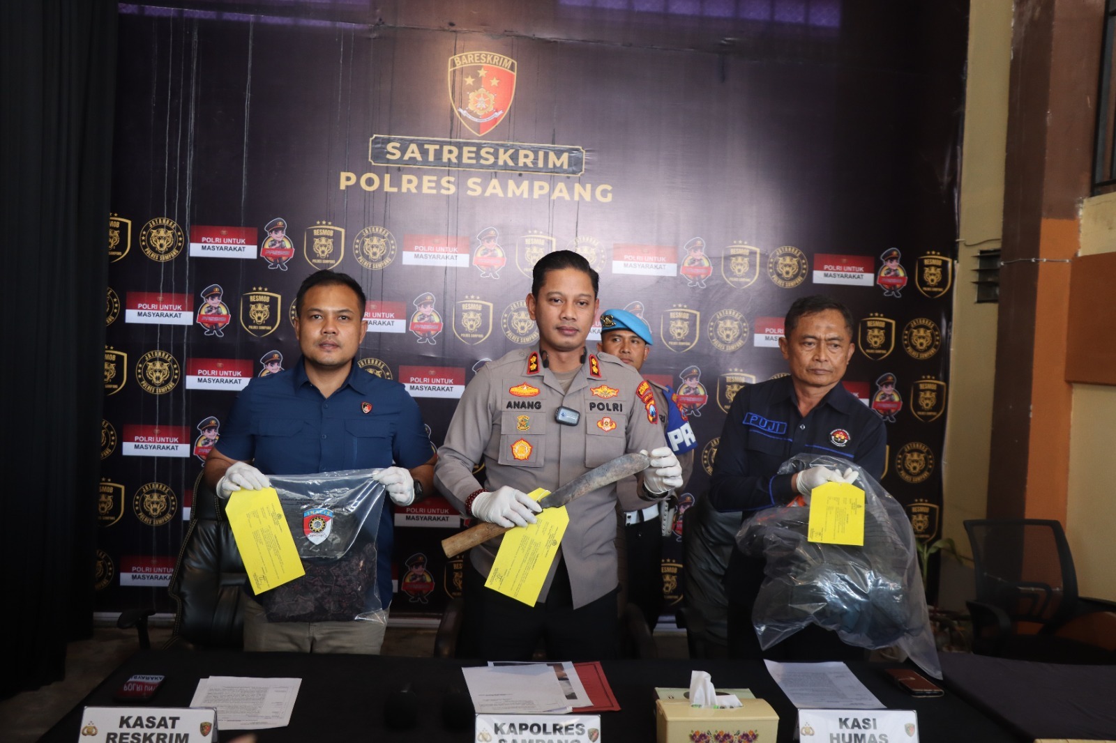 Kapolres Sampang bersama jajaran menunjukkan parang dan barang bukti dalam konferensi pers perkara dugaan pembunuhan