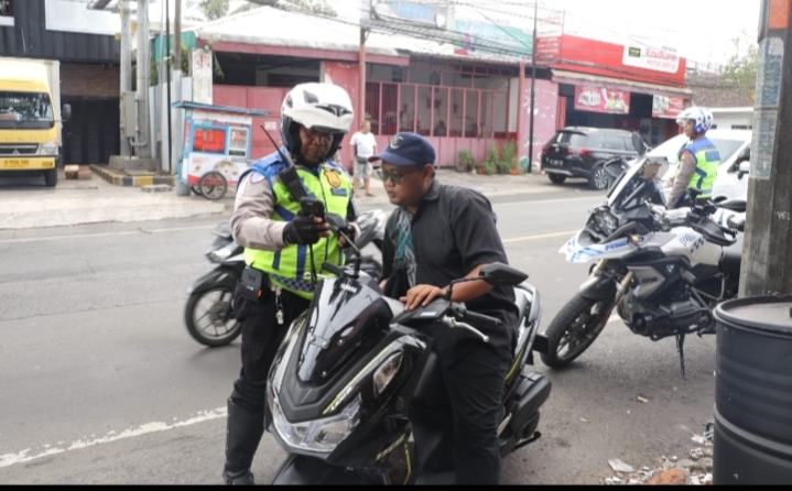 Petugas Ditlantas Polda Jatim melakukan penindakan pelanggaran lalu lintas menggunakan ETLE handheld