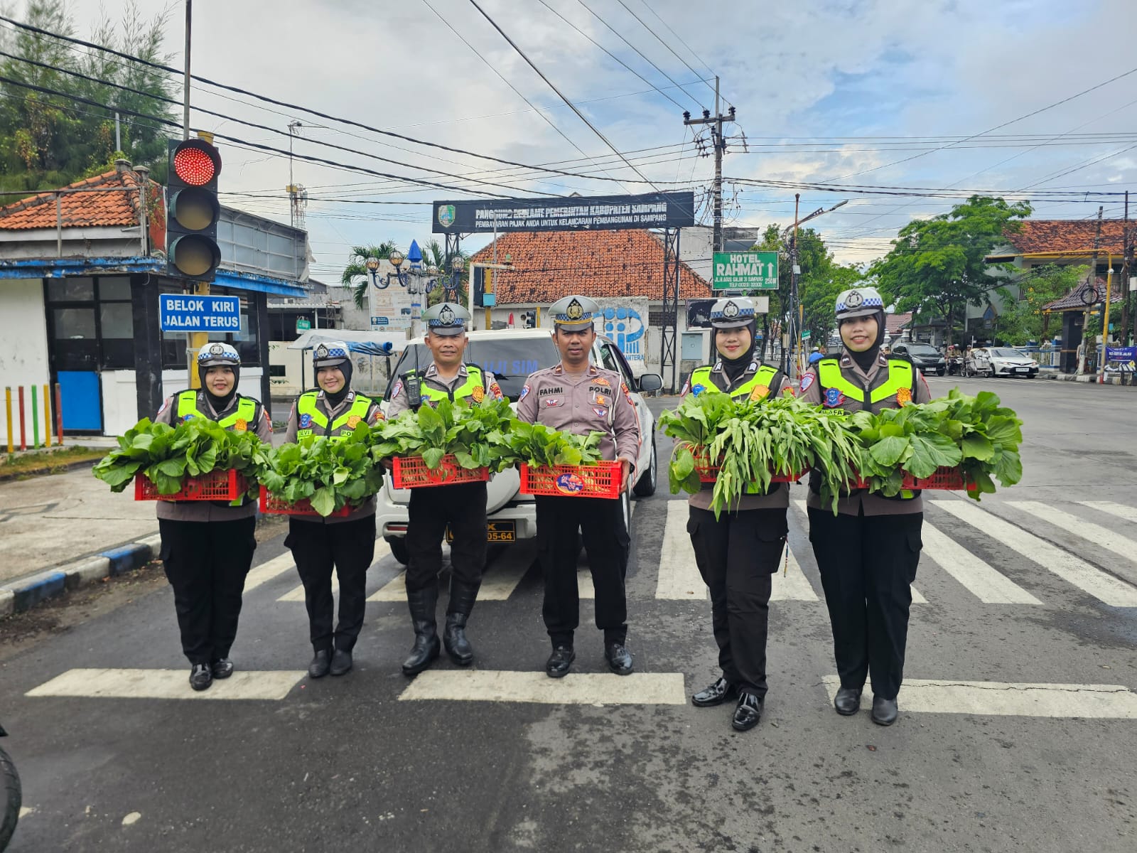 Personel Satlantas Polres Sampang membagikan sayuran segar hasil Program Pekarangan Pangan Lestari kepada pengendara di Monumen Trunojoyo