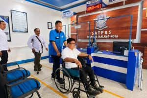 Petugas Satpas Polresta Malang Kota mendampingi penyandang disabilitas saat proses pembuatan SIM khusus difabel