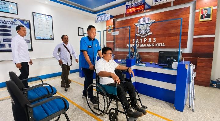 Petugas Satpas Polresta Malang Kota mendampingi penyandang disabilitas saat proses pembuatan SIM khusus difabel