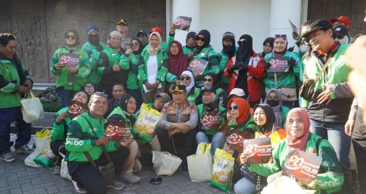 Kapolrestabes Surabaya Kombes Pol Dr. Luthfie Sulistiawan menyerahkan paket sembako kepada perwakilan pengemudi ojek online dan masyarakat di kawasan Tugu Pahlawan.