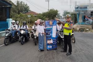 Kasat Lantas Polres Way Kanan bersama personel memberikan sosialisasi aplikasi Siger Lampung Presisi kepada pengguna jalan di Simpang 4 Negeri Baru.