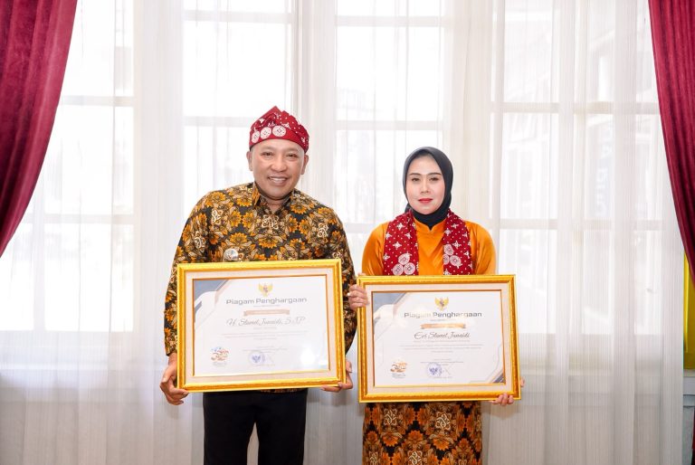Bupati Sampang dan Ketua TP PKK menerima penghargaan Harganas ke-33 Jawa Timur.