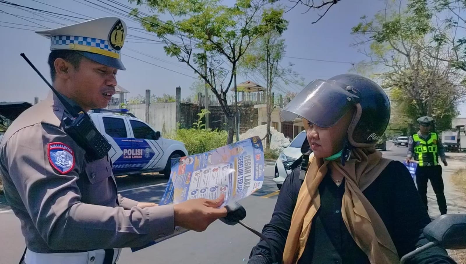 Satlantas Polres Sampang membagikan brosur keselamatan berkendara kepada pengguna jalan