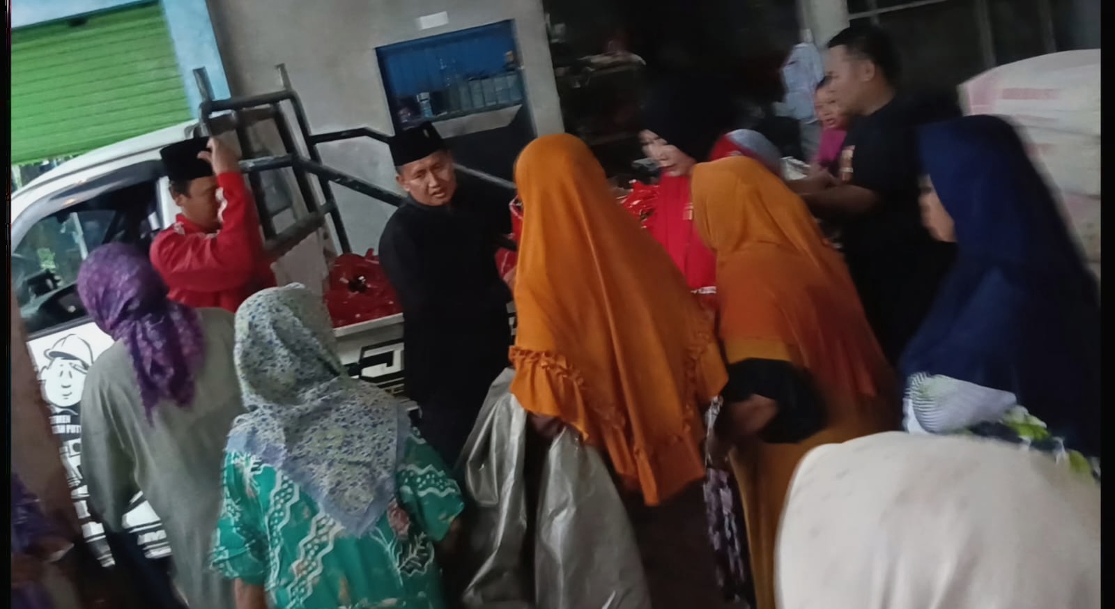 Wakil DPRD Sampang Iwan Efendi menyerahkan sembako gratis kepada warga Kecamatan Sampang meski diguyur hujan