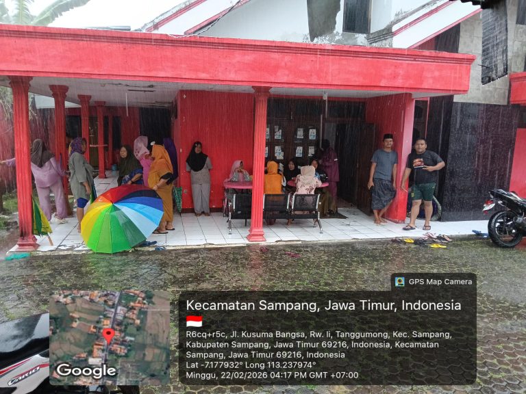 Warga Kecamatan Sampang berteduh saat hujan deras sebelum menerima sembako dari Wakil DPRD Sampang